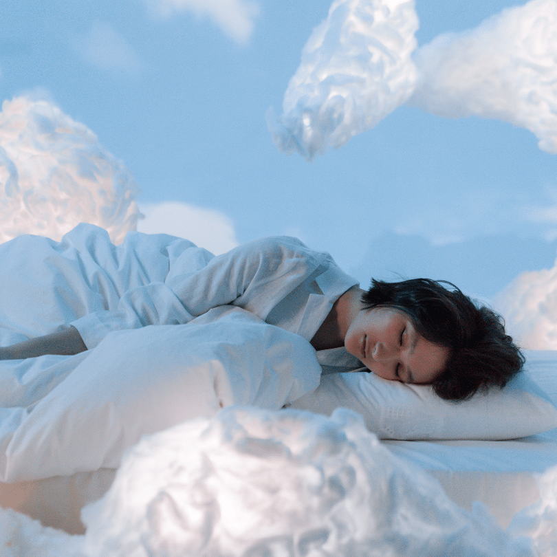 Woman peacefully sleeping on a cloud-like bed, symbolizing Ashwagandha’s sleep-enhancing benefits on Zaira Natural.