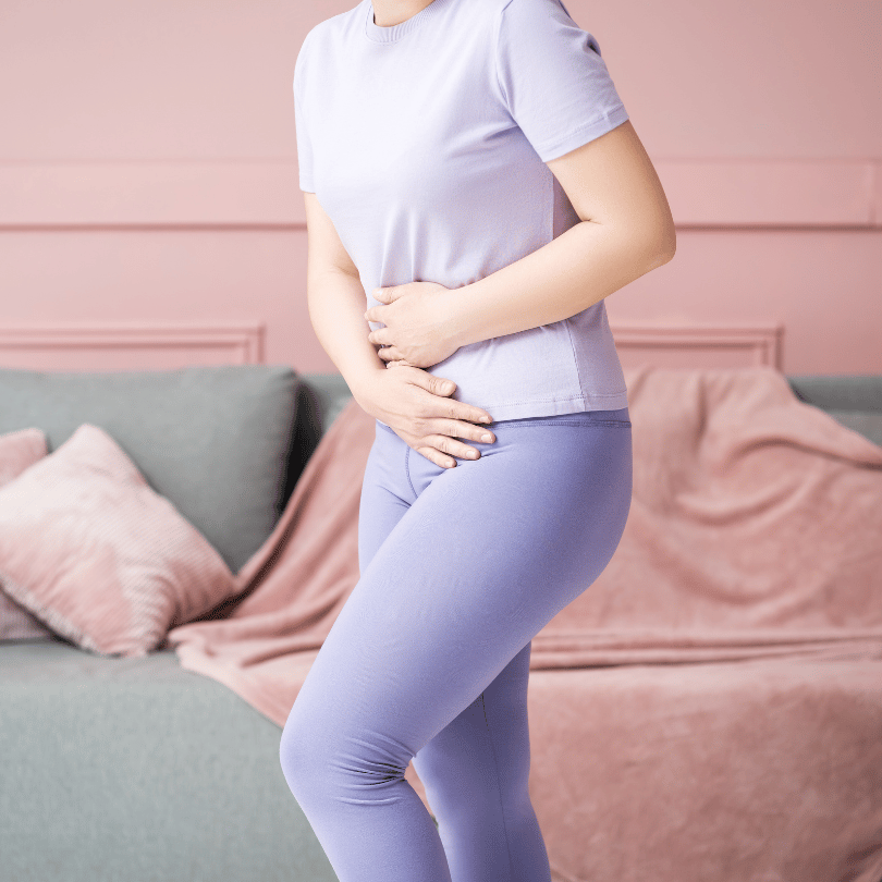 Woman holding her abdomen, symbolizing urinary health support with Zaira Natural’s Swedish Herbs Mix.