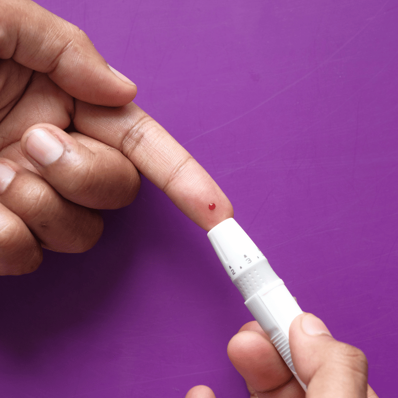 Close-up of a person checking blood sugar levels, highlighting Tribulus fruit's potential role in blood sugar management.