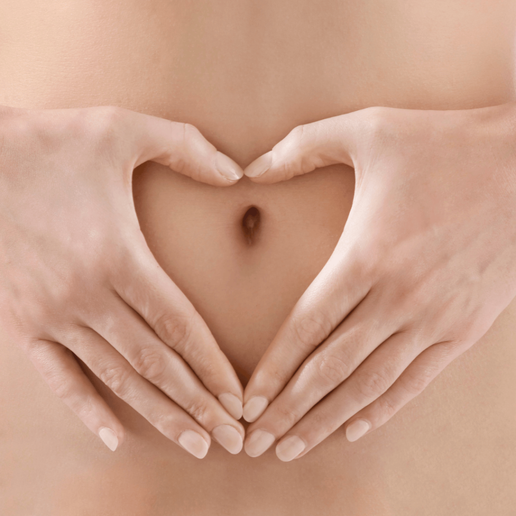 Hands forming a heart shape over the stomach, symbolizing digestive health benefits from Moringa by Zaira Natural.